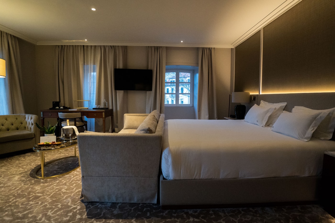 Luxury desert hotel suite with king bed and warm amber accent lighting